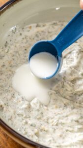Babeurre versé à la cuillère doseuse dans la sauce ranch