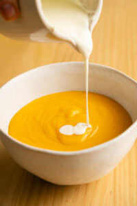 Soupe de potiron - Déposer une cuillerée de crème fraîche au centre de chaque bol et l'étirer en spirale avec la pointe d'une cuillère.