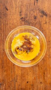 Œufs, sirops, sucre, beurre fondu, vanille et bourbon réunis dans un bol avant de mélanger