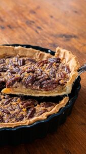 Tarte aux noix de pécan refroidie, la première part soulevée à la pelle