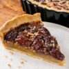 Part de tarte aux noix de pécan sur une assiette, la garniture ambrée sous la couche de noix de pécan brillantes