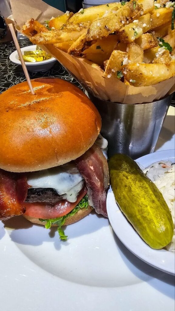 Bacon cheeseburger, cornet de frites à l'ail et au persil, pickle et coleslaw chez 5 Napkin Burger, New York