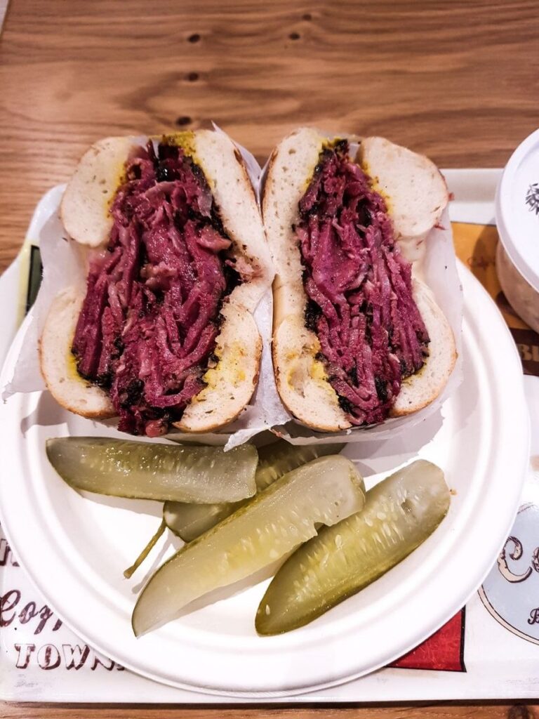 Bagel garni de pastrami et de moutarde, avec trois pickles, chez Tal Bagels, New York